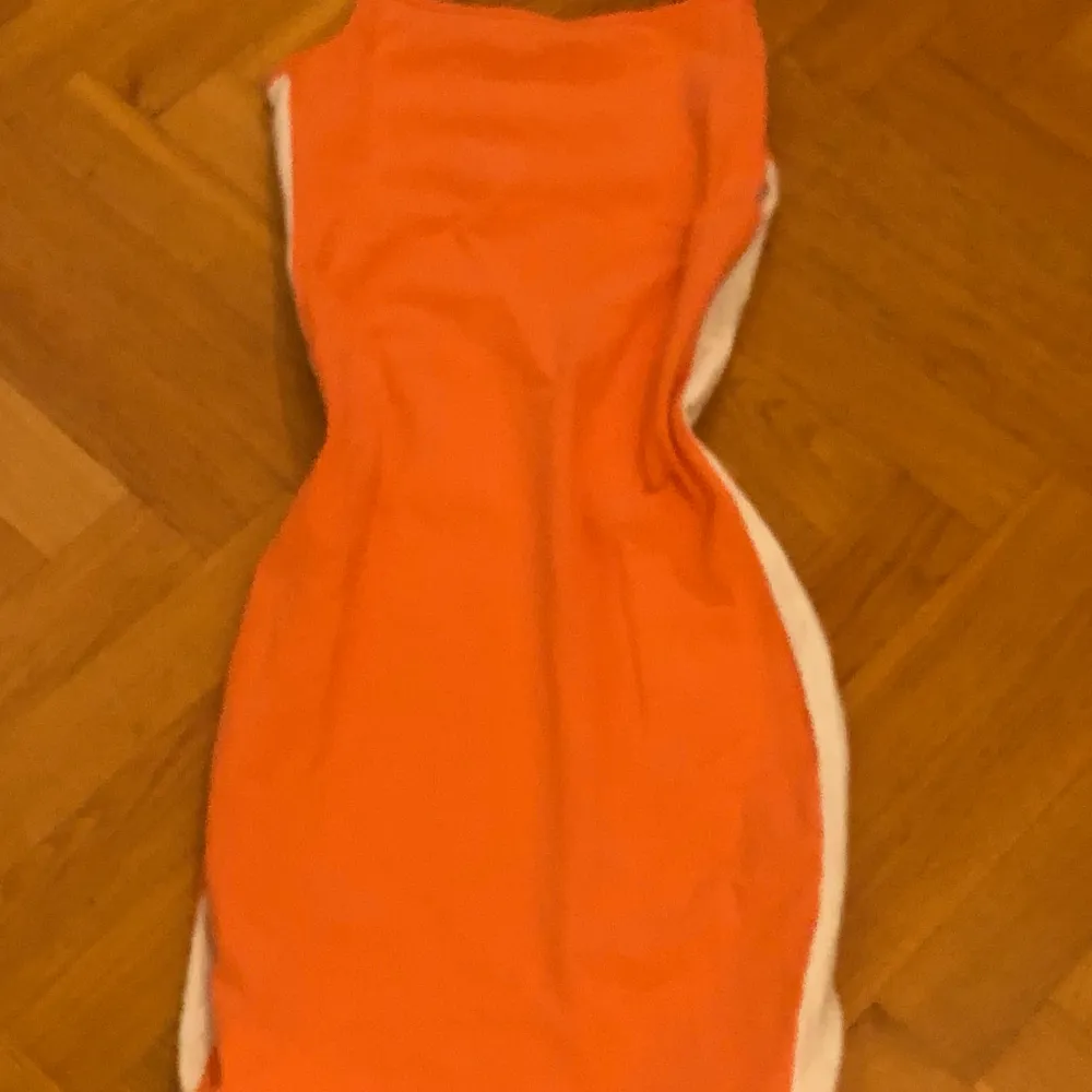 Orange klänning med vita streck på längs sidorna. I mycket bra skick och knappt använd 🤍. Klänningar.