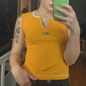 Linne från Reebok - Gulligt y2k linne från reebok i strl M. Ryggen är vit med ”95” tryckt i gult. Använt men bra skick. 