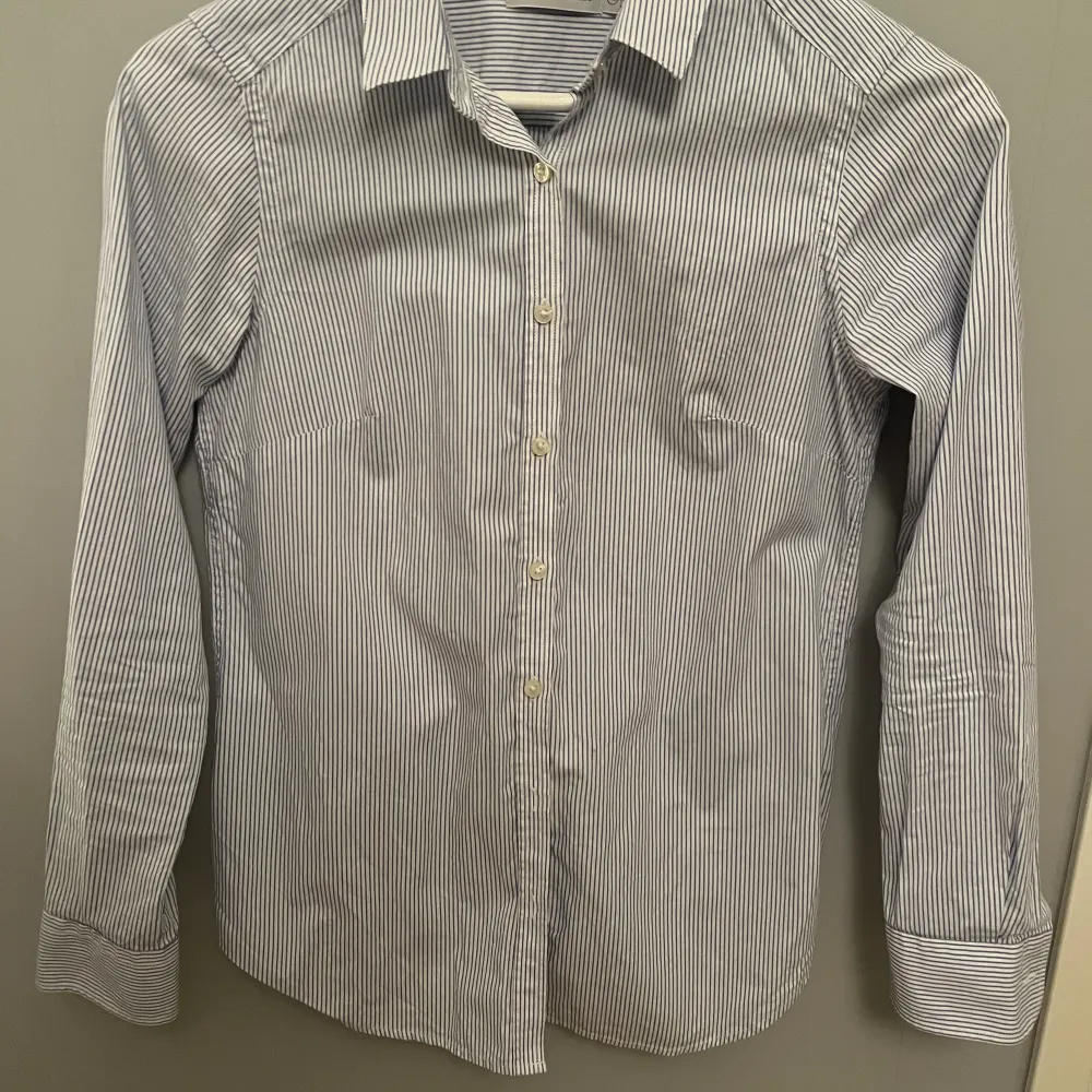 Ljusblå randig skjorta från PeakPerformance i perfekt skick, lätt figursydd.. Skjortor.