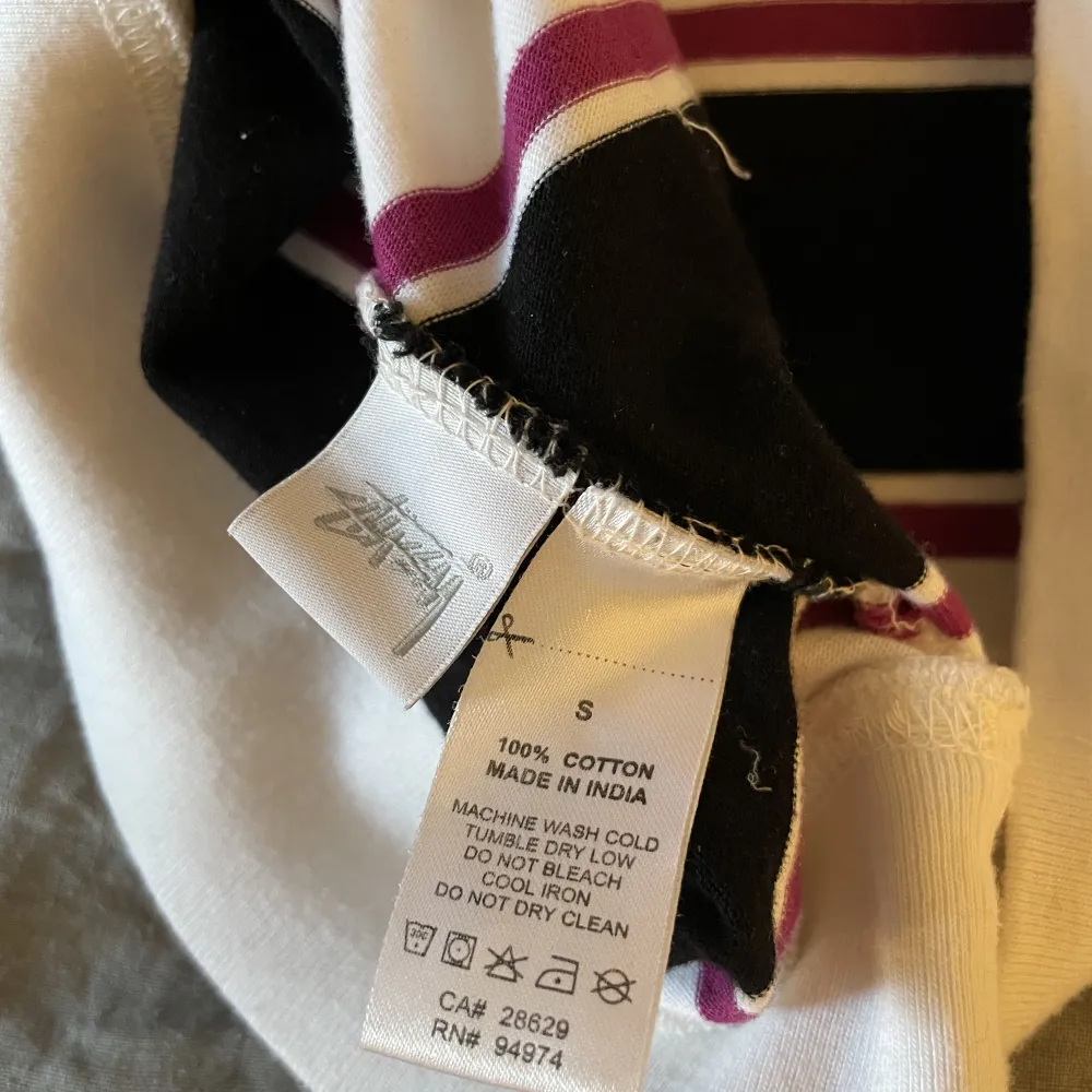 Stüssy hoodie med ränder i vit, svart och lila/röd. Bra skick, köpt second hand därav en liten fläck där bak men inget som stör. Snabb leverans, fler bilder finns . Hoodies.