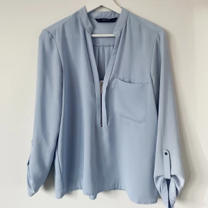 Blus från zara - Märke: Zara Vad: Blus Storlek: Small Upplevd i storlek: Normal Färg: Ljusblå Material: Vet ej då jag klippt bort lappen, skulle chansa på polyester Skick: Synade den nu & ser att det är tråddragningar fram & bak (se bild) men inget som direkt syns när man