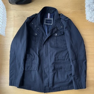 Tommy Hilfiger Field Jacket - Tja! Säljer nu min riktigt snygga Tommy hilfiger field jacka som tyvärr är för stor. Den är varm och funkar både för höst och vinter. Skicket är 10/10 finns inga tecken på användning alls! Strlk M men passar mer som L. Tveka inte att skriva vid frågor!!