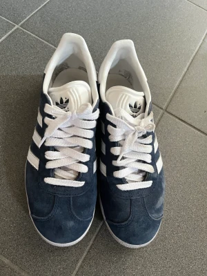 Adidas gazelle mörkblå - Använda två gånger så mycket bra skick. Storlek 38 2/3 passar mig som är en 38. Inköpta på adidas hemsida. Nypris: 1099 :-