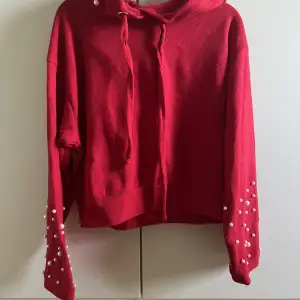 Röd croppad hoodie med pärlor på huvan och ärmarna, från Chiquelle. Använd kanske 3 gånger och har inga synliga defekter eller skador, utan är i så gott som nyskick! ✨💌