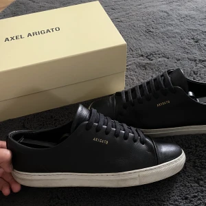 Axel Arigato skor - Väldigt fina skor, fint använda. Smutset på Sulorna går enkelt bort med borste och medel. Köpte digitalt för 2200kr. PRIS GÅR ATT DISKUTERA, försten till kvarn. Det är storlek 43 passar även en 42.
