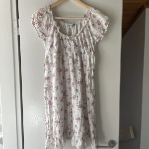Vintage sommarklänning - Gulligaste vintage sommarklänningen med rosa rosor. Har snöre under bysten så går att knyta till önskad storlek.