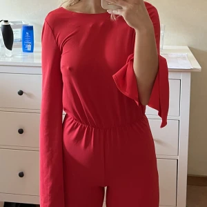 Röd lång ärmar jumpsuit med öppen rygg - Jätte fin jumpsuit som sitter jätte snyggt!  Säljer då den inte kommer till användning. Storlek 34. Använd 1 gång 