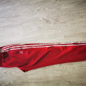 Röda Adidas  Originals retro trackpants. Aldrig använda pga fel storlek. :( Supersnygga å annorlunda, med en riktigt snygg röd färg.  De är storlek M men skulle säga att de sitter som storlek S mer. Nypris 799kr Köp dessa å gå runt å skin i sommar!
