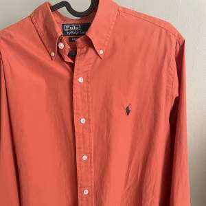 Orange Ralph Lauren skjorta i nyskick. Säljes pga fel storlek. Passar perfekt till sommaren.