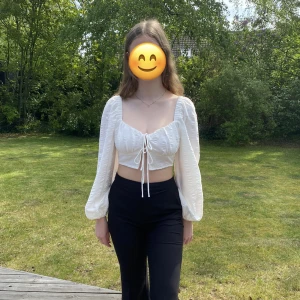 Croppad top - Krämvit Croppad topp från Gina Tricot, två knytningar i fram, smock i ryggen, endast använd 1 gång, nypris: 360