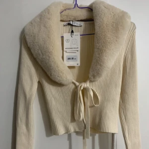 Krämvit långärmad tröja med fejkpäls - Oanvänd och har prislappen kvar. Storlek S och normal i storleken.