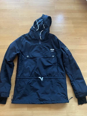 Skidjacka  - Skidjacka med lite fodrad Fack för liftkort, har en stor ficka fram på magen.  Anorak, dragkedja på båda sidorna.