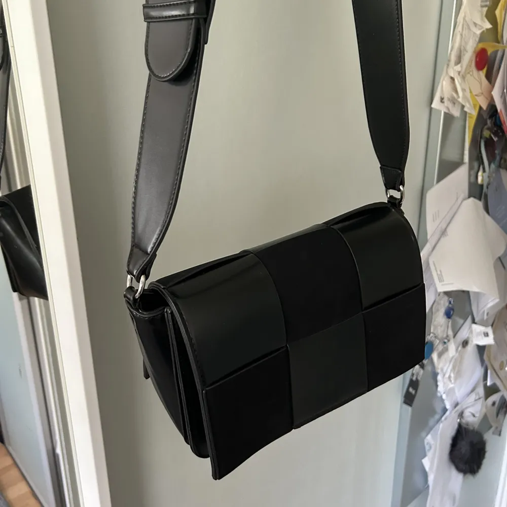 Snygg svart handväska med mocka mönster framtill. Långt band så snygg att ha cross-over. Får plats med mycket! Bra skick. Väskor.