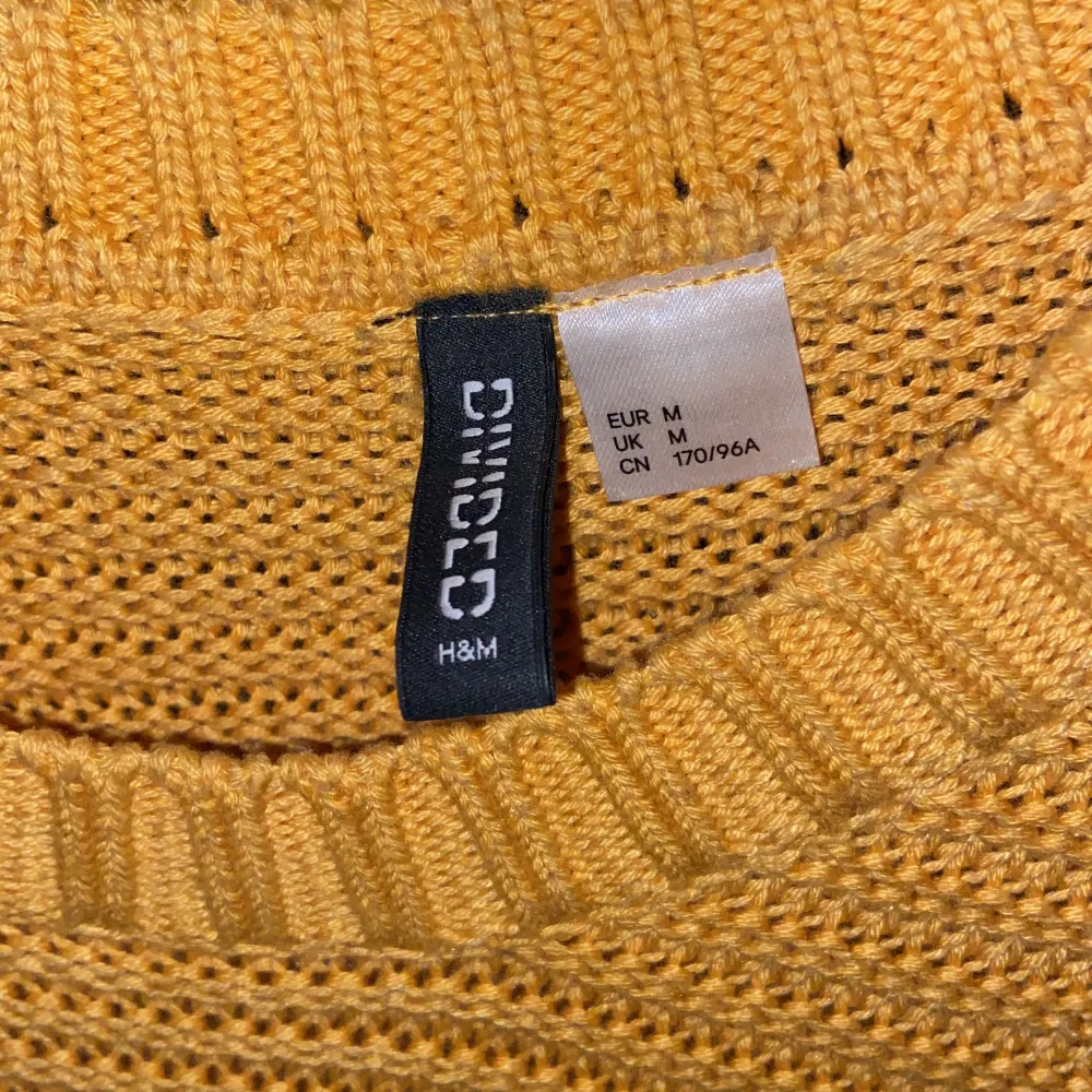 En gul, stickad tröja från h&m, fint skick men de finns några små hål där garnet dragit upp sig ( inget som märks) storlek: M . Stickat.