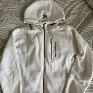 Sail Racing Hoodie Vit - En vit SailRacing hoodie med dragkedja🌼 Storlek 150 barn, funkar för xs-s men lite kortare i ärmarna🌟bra skick!