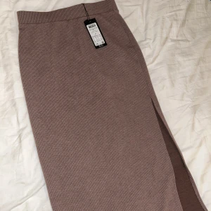 Sett, kjol & tröja - Superfint ljusbrunt sett med en kjol med slits & en tröja med justerbar scrunch (går att få till en Crop top men även vanlig längd). Aldrig använt!