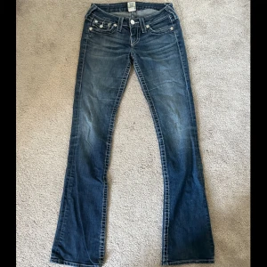 Jeans från True Religion - Snygga straight jeans från True Religion storlek 25 (däremot efter att ha mätt dem i midjan så är dem teknist sett storlek 26 / ca 35cm). Innerbens längden är ca 80cm, jeansen är ca 17cm lågmidjade och 20cm vida. Jeansen är även lite stretch & i bra skick
