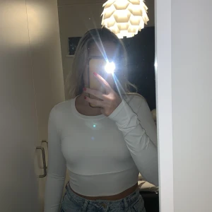 Vit träningstopp - Säljer denna träningstopp från shein. Dock bra kvalitet med rejält material. Inköpt för ca 1,5 år sedan och  har utstått mycket tvättar men med samma kvalitet. Hål på varje ärm för tummar. OBS köparen står för frakt och jag ansvarar inte för postens slarv