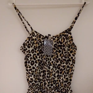 NY & oanvänd leopardmönstrad byxdress. Storlek: 34/XS. Helt felfri. - Helt NY och oanvänd leopardmönstrad byxdress. Har resår i midjan, 2 fickor, och reglerbara axelband. Storlek: 34/XS. Material: Bomull/Viskos. Inga defekter/fel. Lappar/tags sitter kvar sedan inköpet.