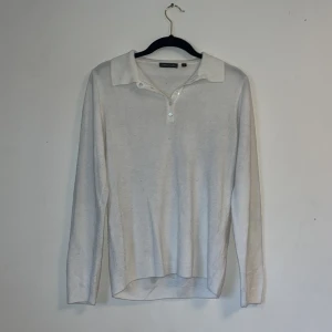 Vit tröja i bomull  - En vit tröja som inte har några tecken på användning förutom att den är något nopprig.