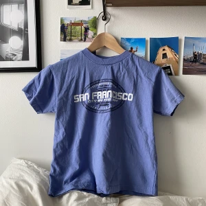 Blå baby tee - Blå baby tee från San Fransico köpt runt 2010. Fint skick, inga hål eller liknande!💙