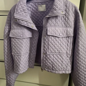 Croppad jacka - En croppad jacka från berschka i lila färg. I helt nytt skick. 