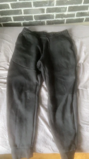 Svarta Nike Tech Fleece byxor - Jag säljer mina svarta Nike Tech Fleece byxor dom är knappt använda och det fins inga hål eller några andra slaks skador på dom 