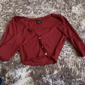 Röd långärmad crop top - Tröjan är väldigt kort och kan inte knäppas upp