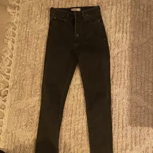 Svart/gråa skinny jeans med många knappar. Bra skick, bara använda några gånger. 