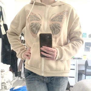 Huvtröja  - Beige Huvtröja med stenar. Helt oanvänd bara testad. Väldigt bekvämt och mjukt material med stor luva.