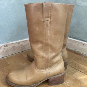 Skinnstövlar cowboyboots  - Otroligt coola skinnstövlar/boots. Beige, kommer bli snyggare och snyggare ju mer som används. 