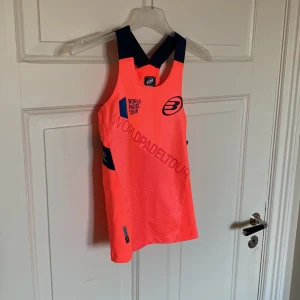 Träningslinne från Bullpadel - Säljer denna snygga träningslinne från Bullpadel. Helt ny med lapp kvar. Storlek 12 (barnstorlek). Nypris 37.10 pund, motsvarar ca 434kr. Färgen är neonröd/orange. 