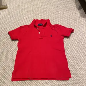 En röd piké tröja från POLO, RALPH LAUREN. Pojke 5 år.