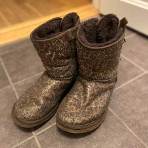 UGG bailey bow glitter Limited glittriga leopard uggs, höga med två rosetter baktill Original kartong medföljer En vit målarfärgs fläck (bild) samt lite slitna på insidan men annars mycket fina och inget man tänker på!