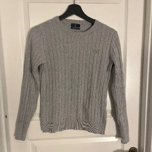 Stickad Gant tröja - En ljusgrå kabelstickad tröja från gant i storlek S. 