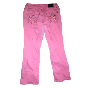 Your pink Arizona boot-cut jeans rock a cold sign on the back pocket with prime stone wing details, low waist, and a touch of bling. Plus, a subtle stain adds a hint of lived-in character