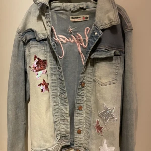 Jeans jacka med broderade gliter stjärna  - Super söt och bekväm jeans jacka från Desigual! Stolek 170 men själv som en S/M kan fordrande ha den. Jackan är av en mjukare jeansmatrial så den mer elastisk än andra jeansjackor. 
