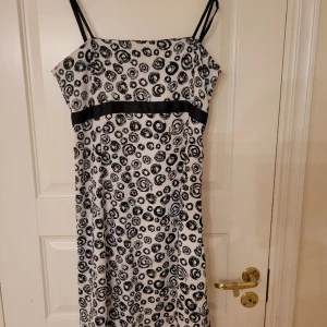 Mönstrad sommarklänning - Vit klänning med svart mönster. Har använts en gång. Perfekt till sommarfesten. Materialet är viskos och bomull. 