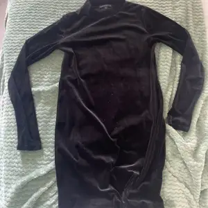 En svart lång sammetsklänning som använts en gång. (Det gröna är från kameran, ej på klänningen)