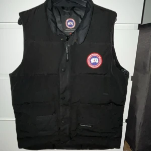 CANADA GOOSE Väst - Säljer min Canada Goose Väst, då jag ej använder den längre och behöver pengarna  Skicket på västen är som ny, använt den ett fåtal gånger   Storlek M passar även S  Nypris: 6500kr Pris:2500  Mötes helst, går även att frakta!! Pris går att diskutera!