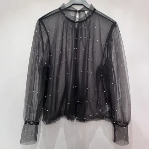 Blus  - Snygg blus från NLY Trend Skirt material med dekorativa pärlor och ballong ärmar. Färgen är grå. Storlek 42 men passar även 38/40