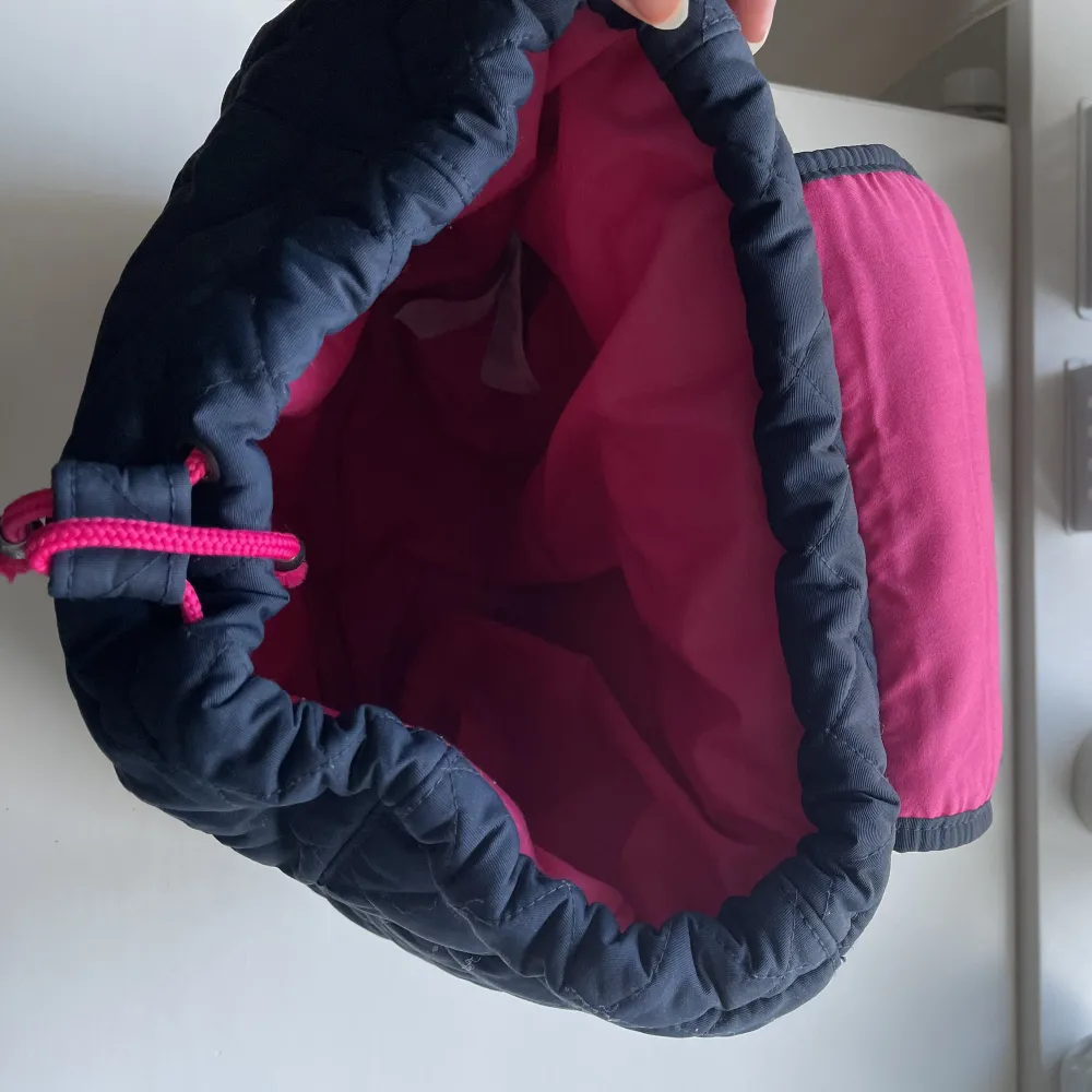 Mörkblå ryggsäck från Hollister med rosa detaljer, väldigt rymlig och i mycket bra skick . Väskor.