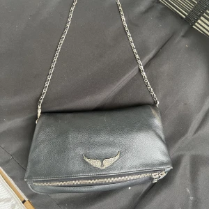 Zadig väska  - Säljer min Zadig väska då den ej kommer till användning. Den är lite sliten men hel. Den långa kedjan saknas tyvärr men kvitto finns om någon är intresserad. 