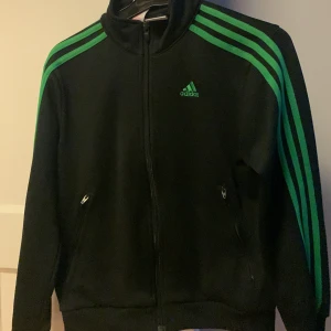 Adidaskofta - Adidaskofta i bra skick! Gröna ränder på armarna. Storlek 9-10 år och funkar till både tjej och kille, pris kan diskuteras!
