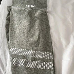 Träningsthights - Träningstights från stronger! Använda, lite skavda på de vita mönstret men annars i bra skick!