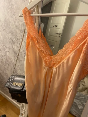 Orange linne  - Suuuper fint orange spetslinne som är perfekt nu till sommaren när man är brun och fräsch. Tyvärr så finns i storlekslappen kvar. Skulle gissa på onesize. Litet hål vid brösten som man kan se på bilden. Frakt köpes till