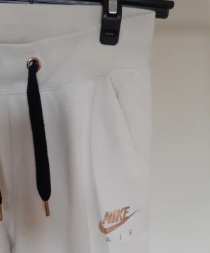 Nike mjukisar strl small. Muddar nere vid foten och snörning i midjan. - Snygga och sköna mjukisar från Nike med muddar nere vid fötterna och snörning i midjan. Nike skrivet på rumpan.