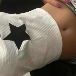 VIT KORT STJÄRNA TOPP RIBBAD - Hejj! Säljer en jätte snygg topp med en svart stjärna på! Skit snygg, ribbad och passar till många olika stilar! Från Shein nypris runt 90 men inte genomskinlig. Storlek Xs men passar definitivt större. 