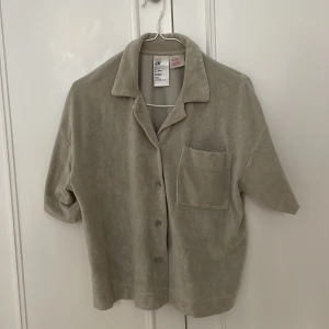 Frottéströja - Sparsamt använd kortärmad frottétröja. Köparen står för frakt 