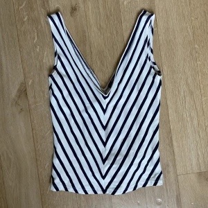 Randigt linne - Gulligt v-ringat o lite croppat linne. Vit/marinblått 